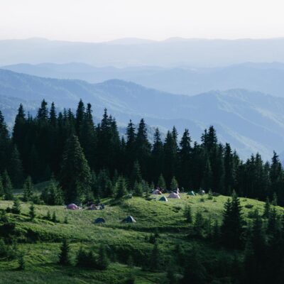 Photo by Rostyslav Savchyn A picturesque view of a campsite in Holda, Romania surrounded by lush greenery and distant mountains.
