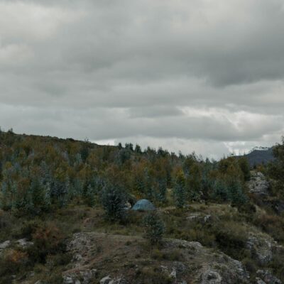 Experience the serenity of camping in the rugged landscapes of Cusco, Peru, under an overcast sky.